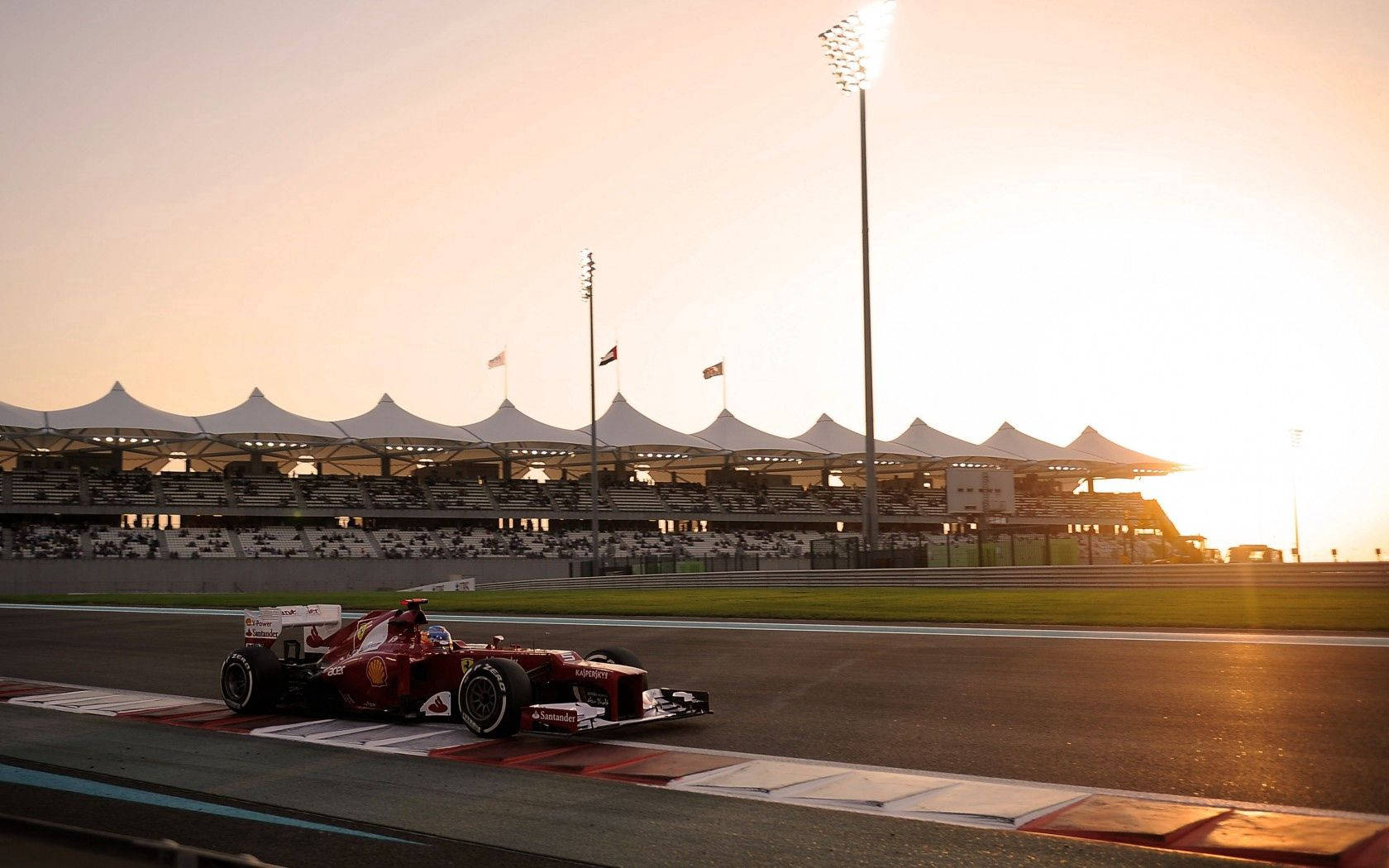 Динамичен изглед на болид от Формула 1 на Ferrari на пистата Тапет