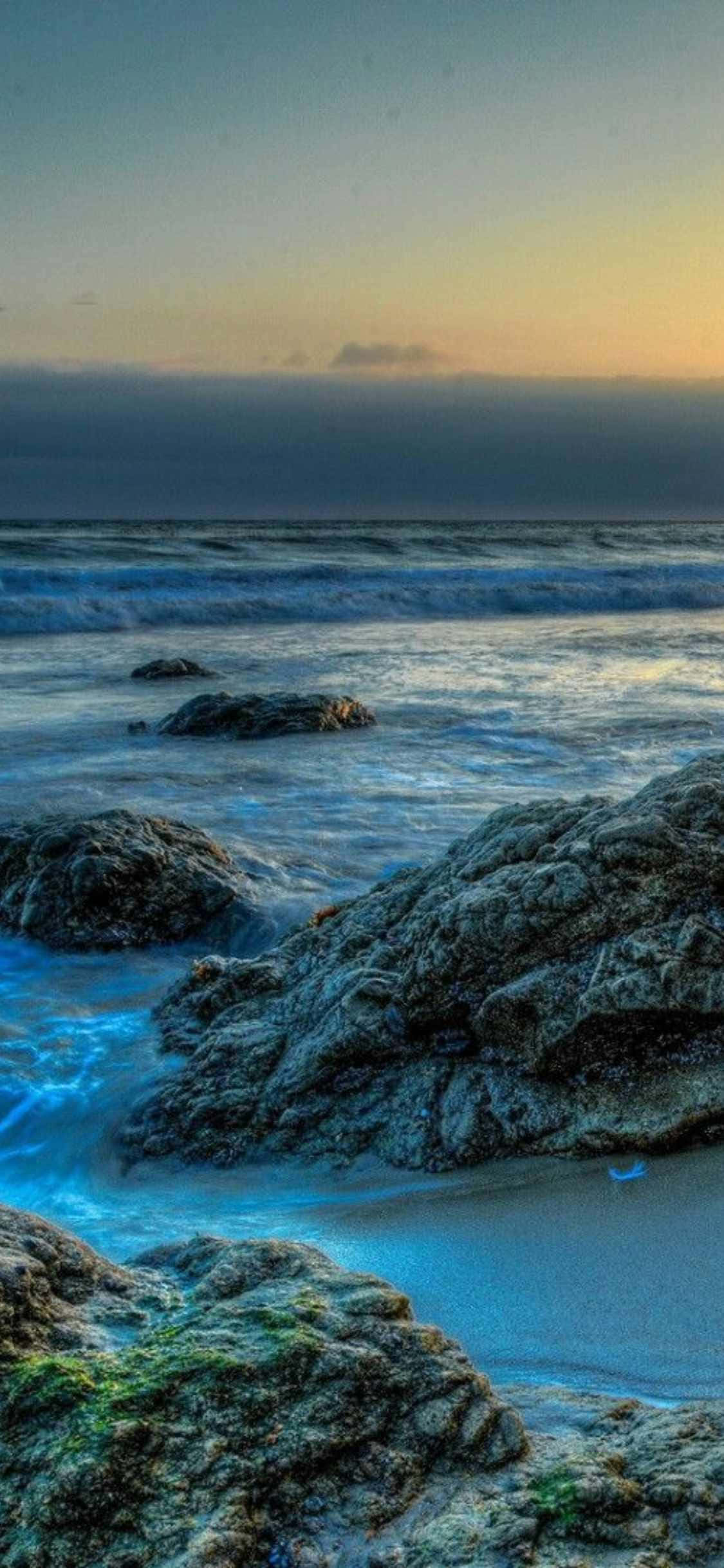 плаж с скали и вода при залез Тапет