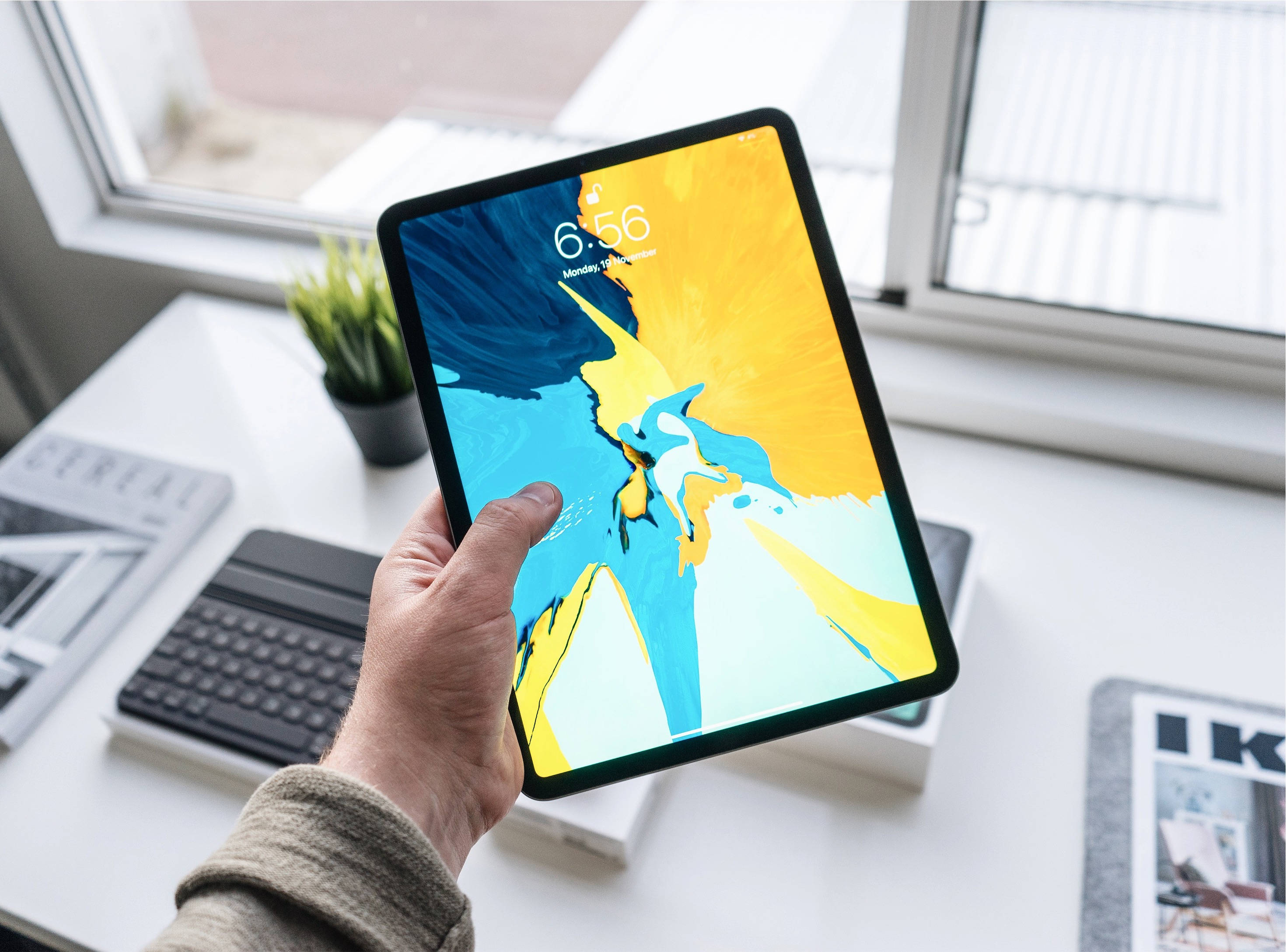 Човек държащ Apple iPad Pro Тапет