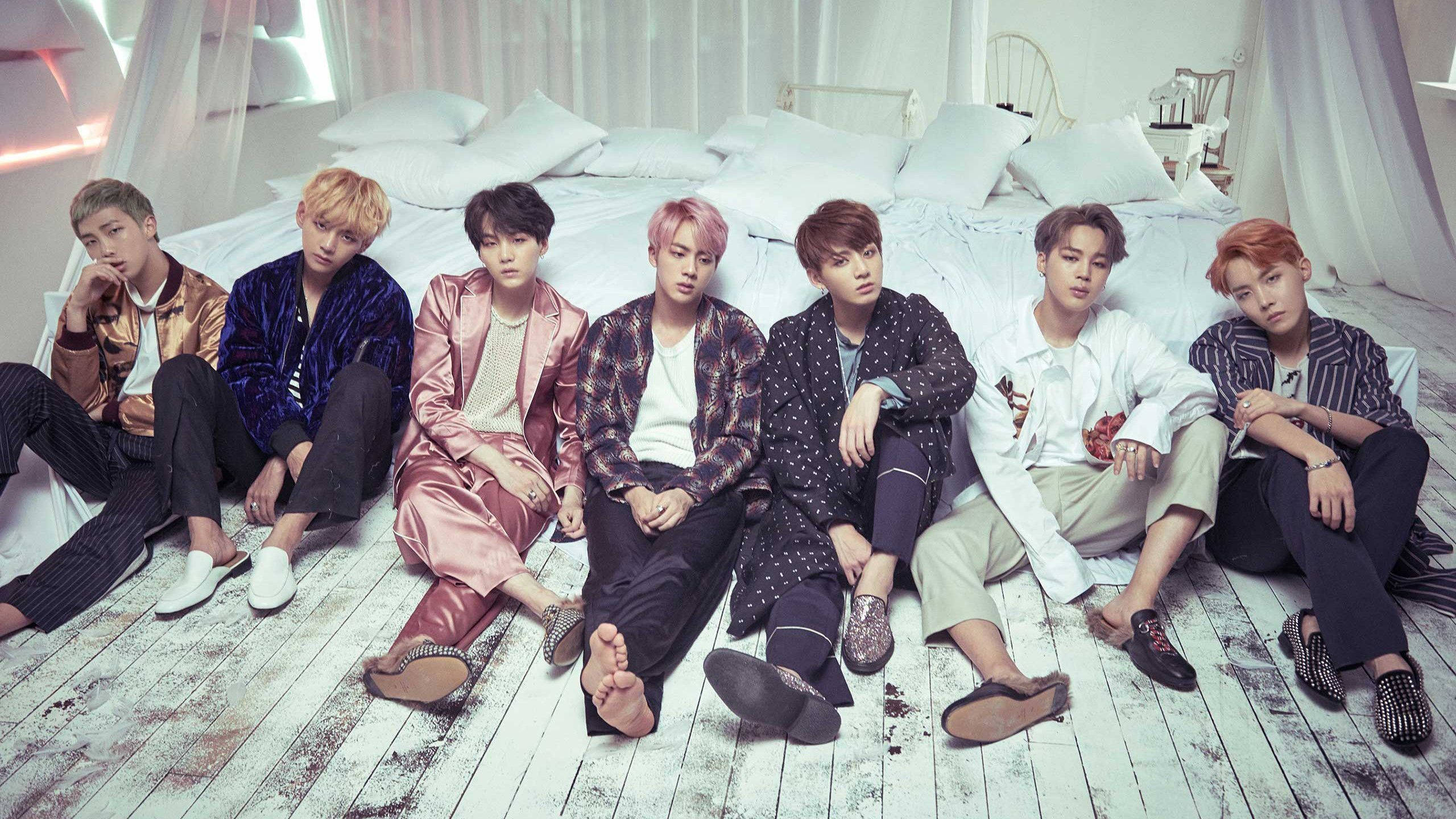 Членове на BTS до легло с лаптоп Тапет