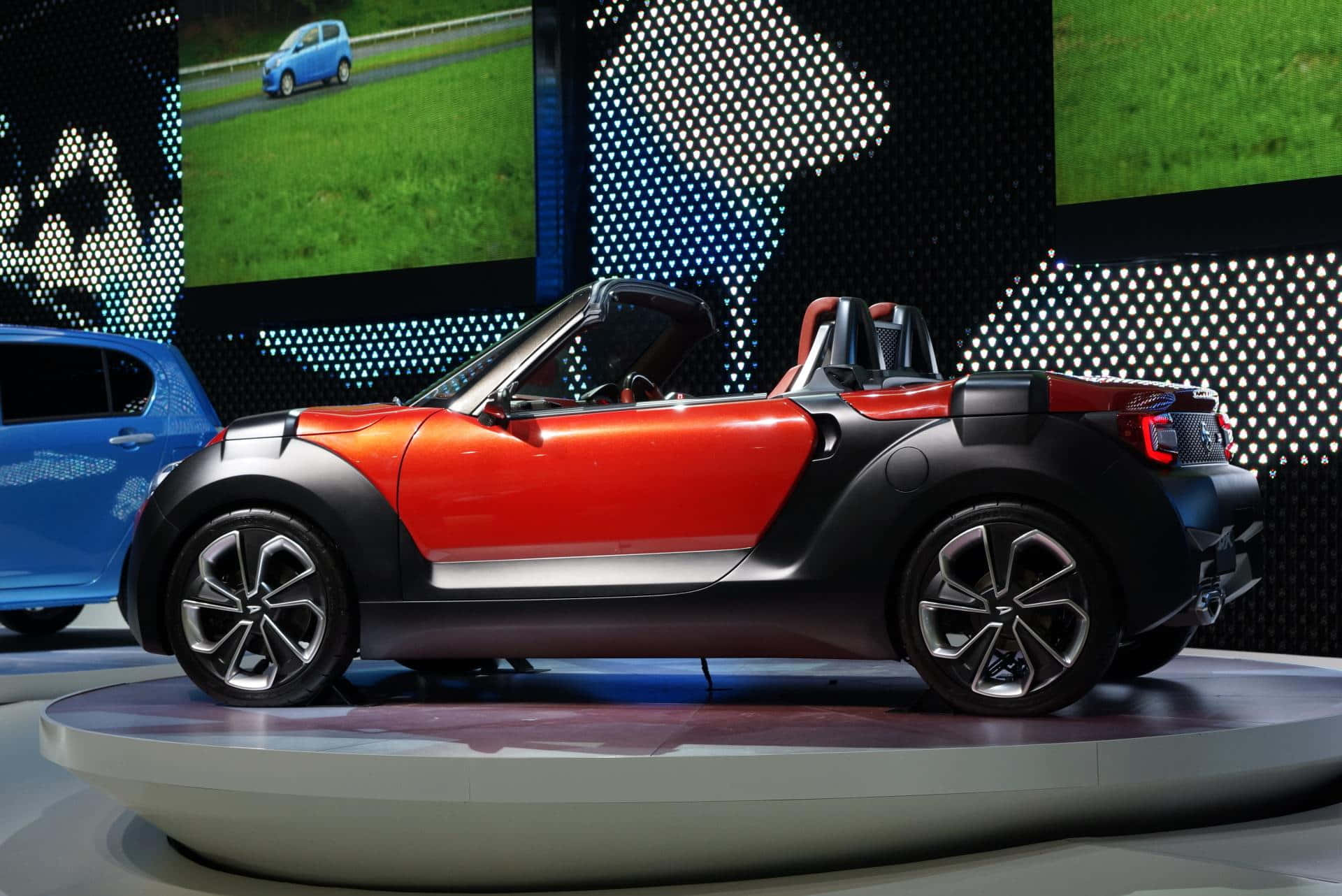 Елегантно червено Daihatsu на открит път Тапет