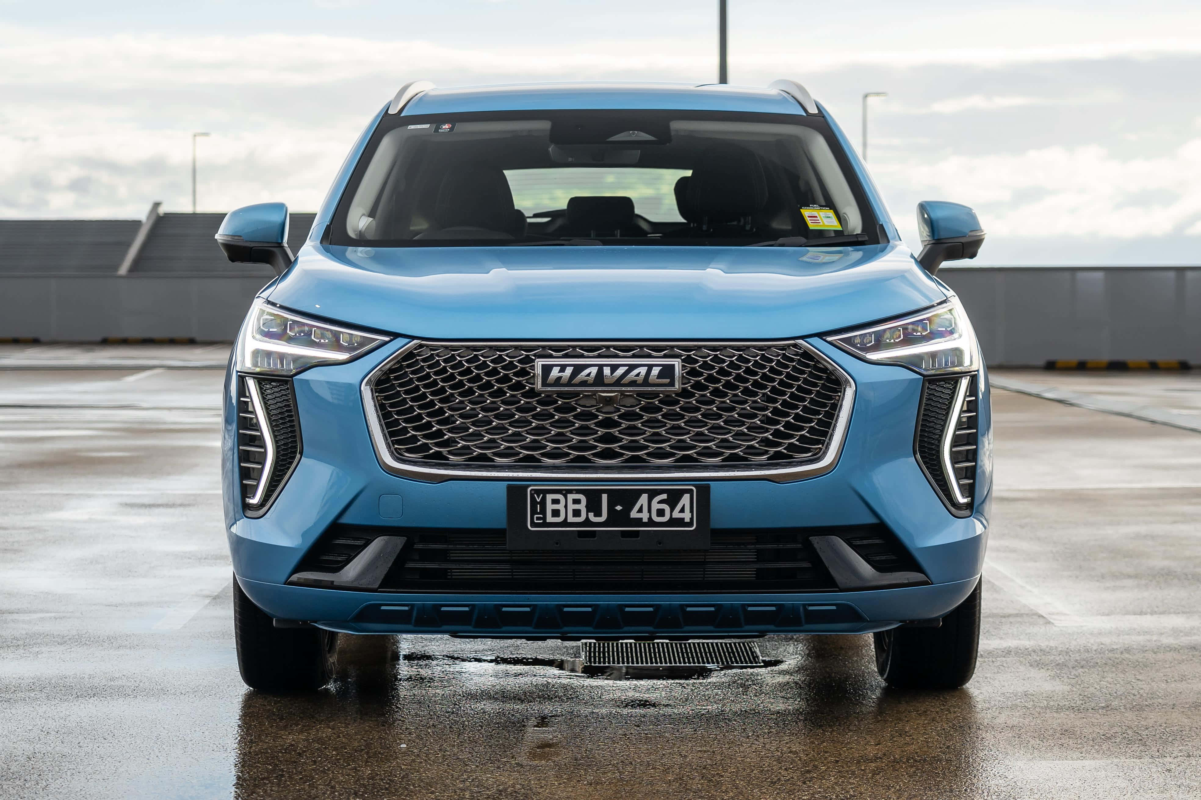 Стилен и съвременен Haval SUV, каращ през обширен пейзаж Тапет