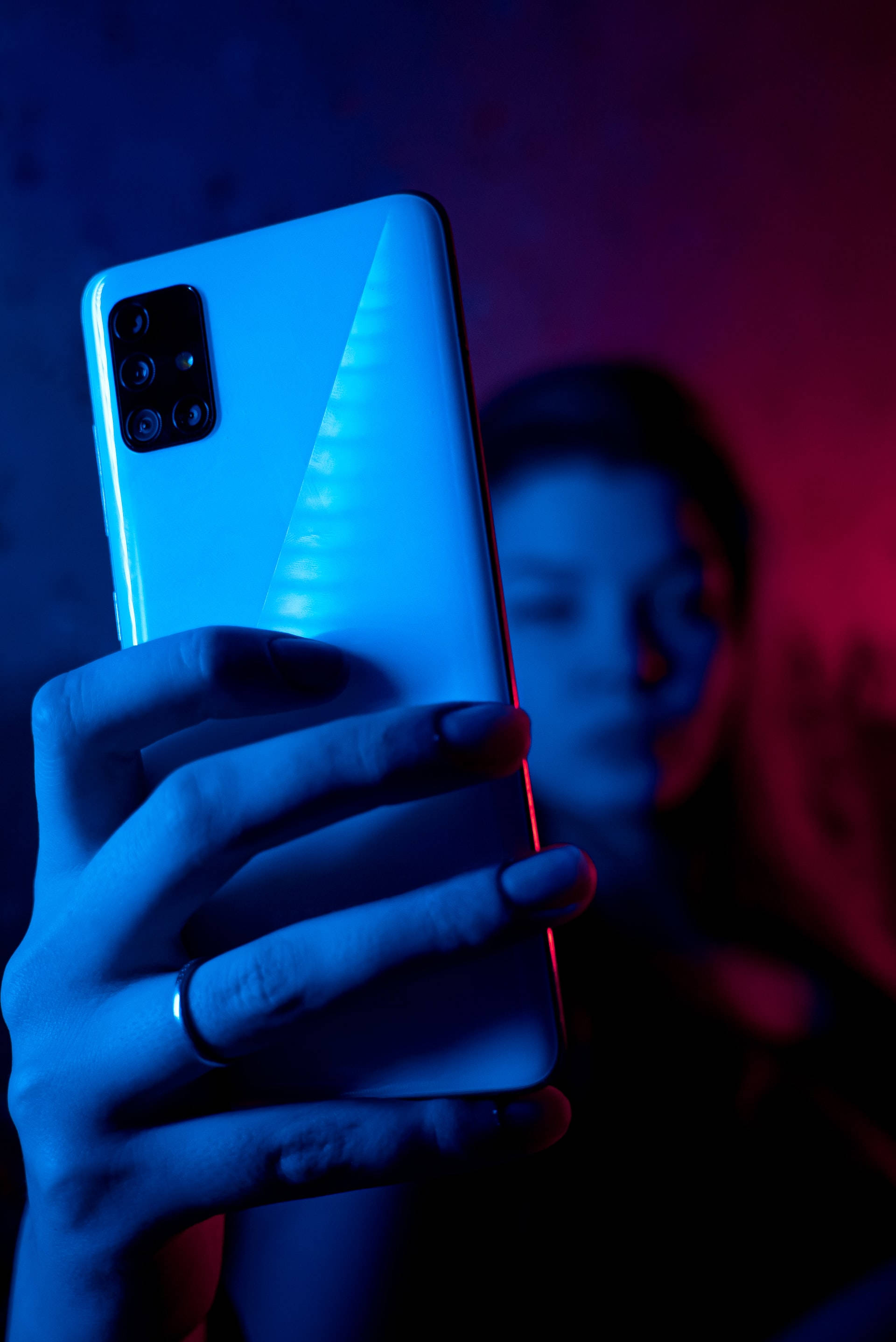 Жена с телефон в неоново син iPhone Тапет