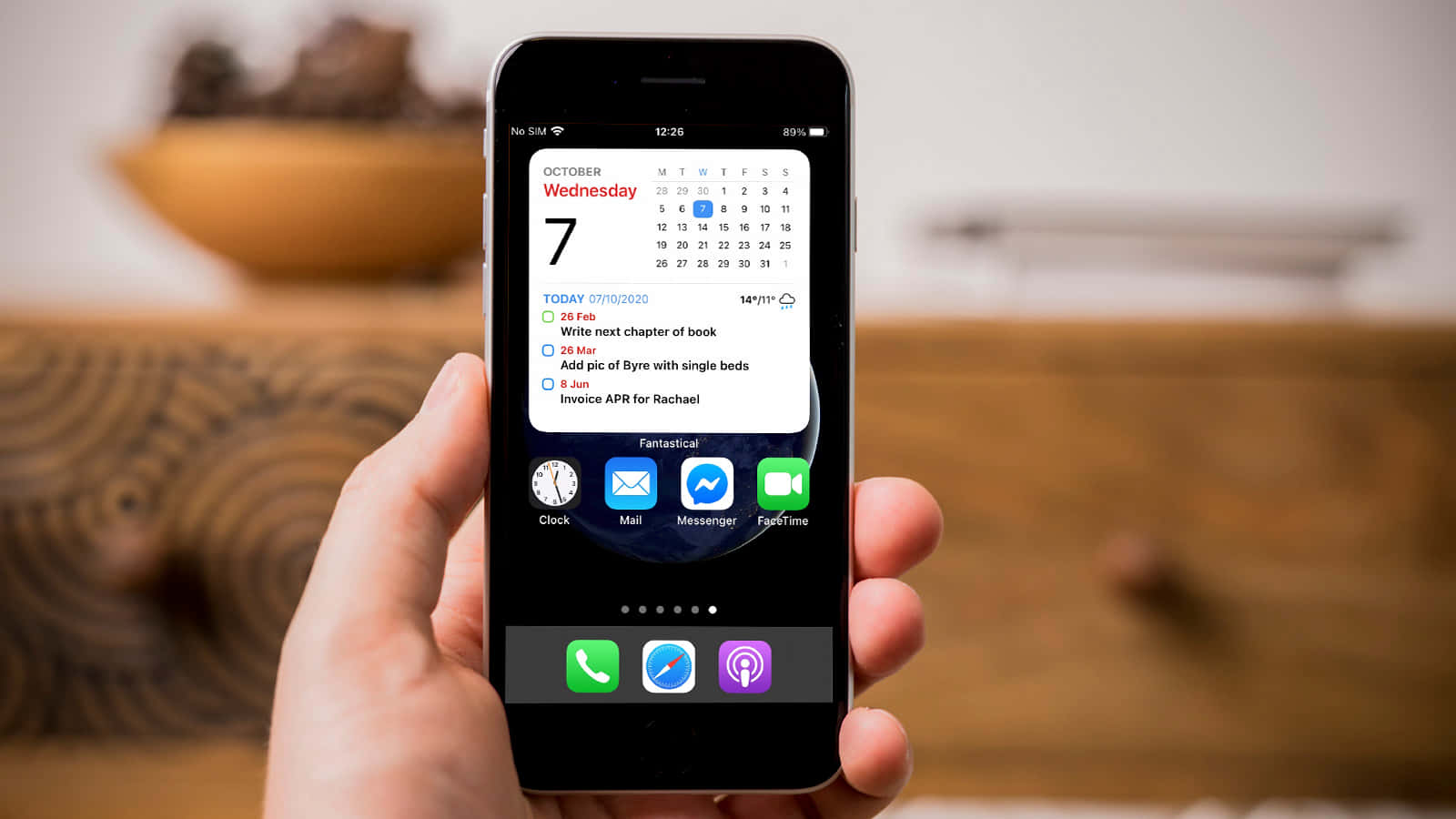 човек държи iPhone с календар на него Тапет