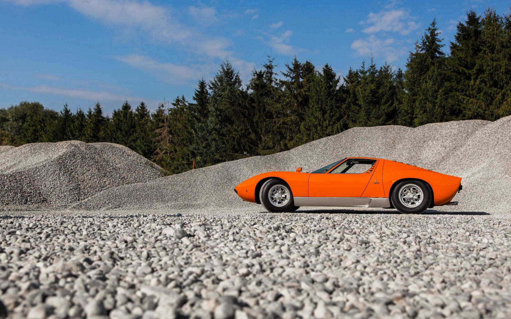 Изискано оранжево Lamborghini Miura на чакълест път. Тапет
