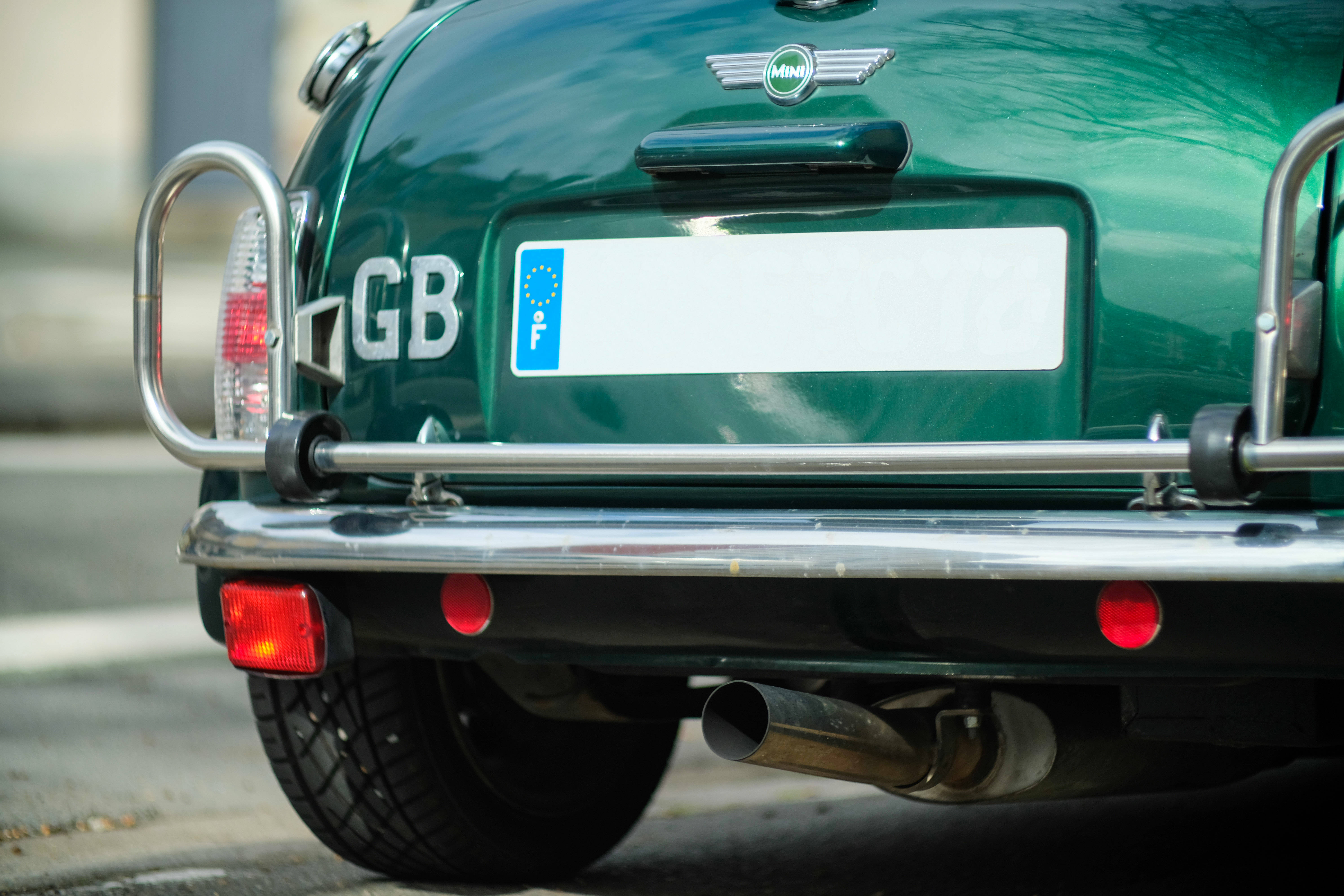 Лого на Mini Cooper на гърба на зелен автомобил Mini Cooper Тапет