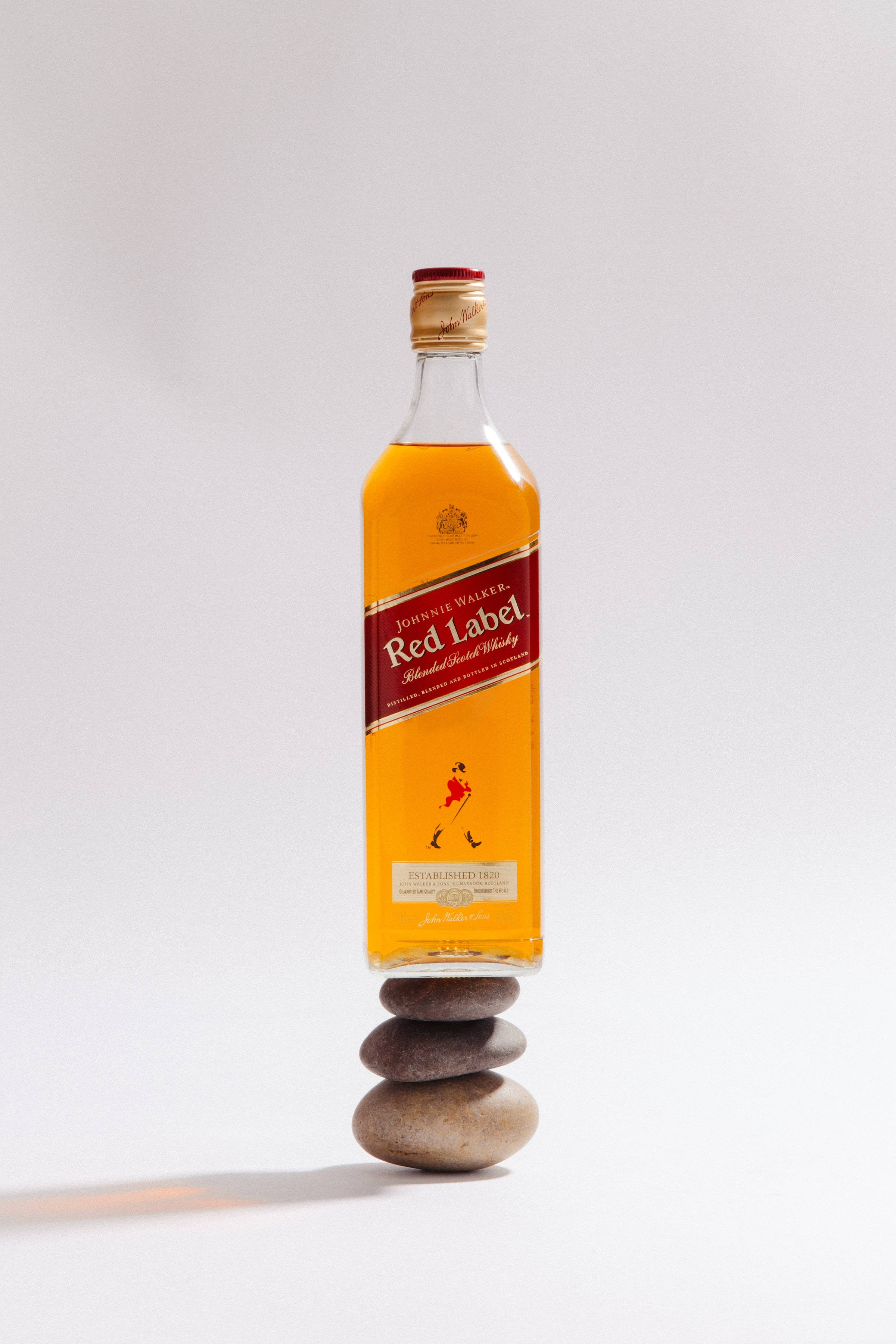 Бутилка уиски Red Label на каменна купчина Тапет