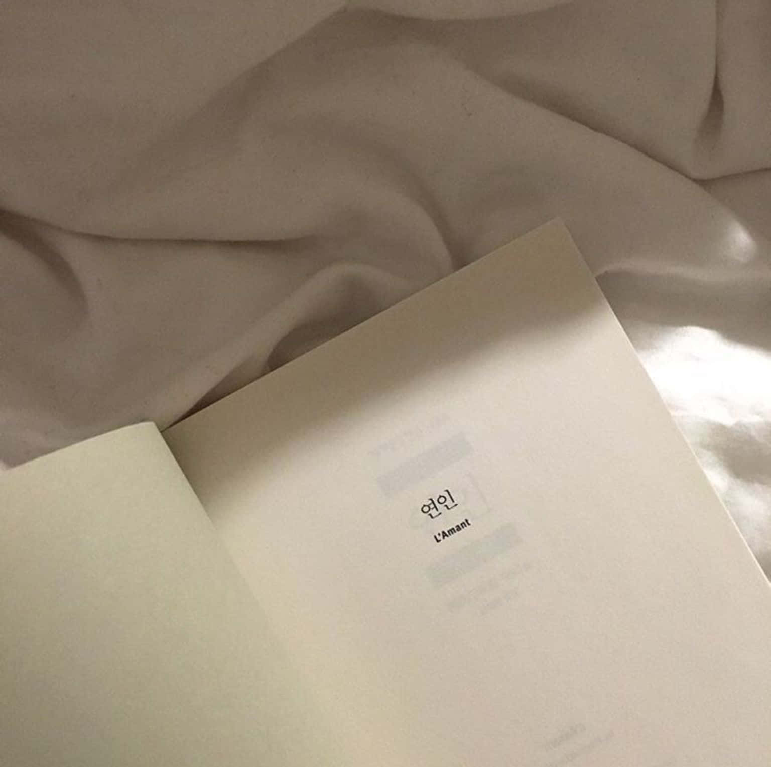 книга с бяла корица на легло Тапет