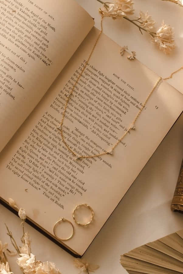 книга с огърлица и пръстен върху нея Тапет
