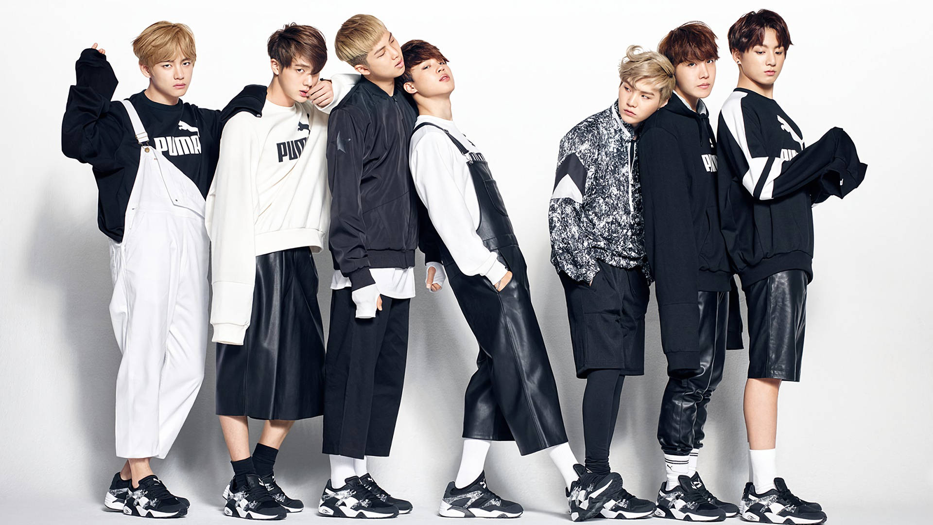Членове на BTS – V, Jungkook, Jimin, Suga, Jin, RM и J-Hope – в черно-бяло облекло.