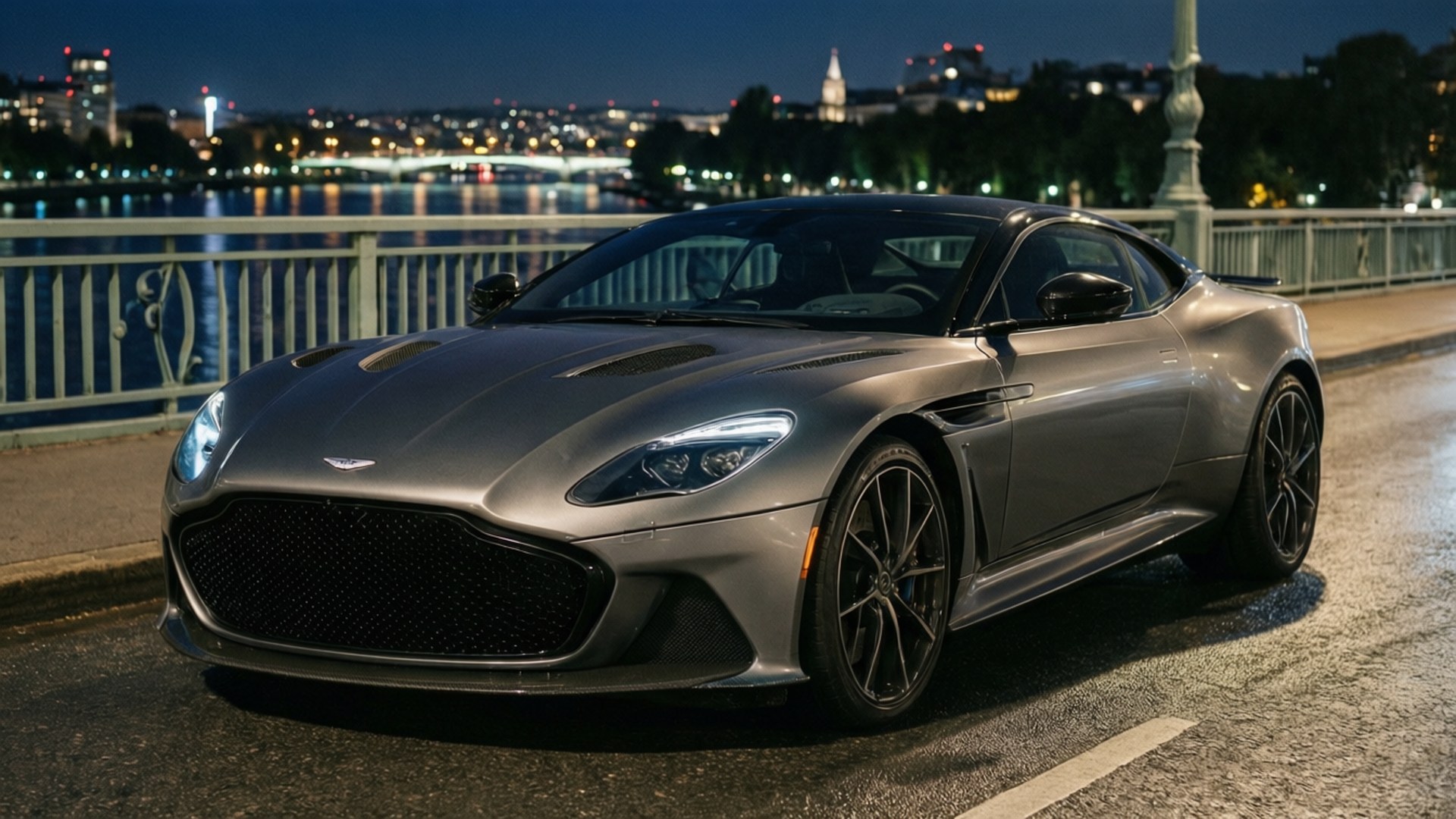 Aston Martin DBS Superleggera на мост през нощта с градски светлини.