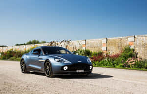Зашемляващ Aston Martin Vanquish в движение по живописен път — Steam Deck Тапет