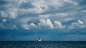 Мрачно облачно небе над морето с плавателна лодка, спокоен морски тапет. — Небесен изглед Тапет