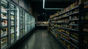 Мрачна нощна сцена на пътека в магазин, осветлена само от блясъка на хладилниците.
